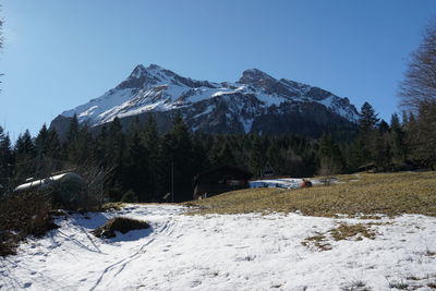 Scenic view of snow covered mountains against clear sky