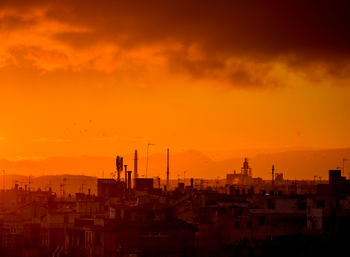 Silhouette buildings against sky during sunset