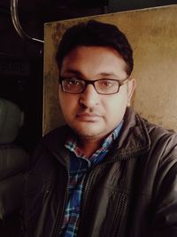 Portrait of young man wearing eyeglasses at home