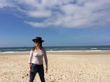 Woman standing on sand against sea at beach