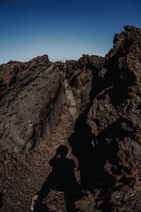 Low angle view of sun shining over rocks