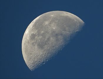 Low angle view of moon against clear blue sky