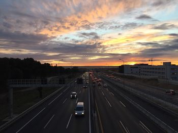 Traffic on road against sky during sunset