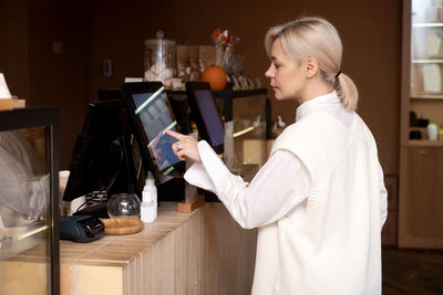 A cute girl makes a contactless order on an electronic scoreboard in a cafe person