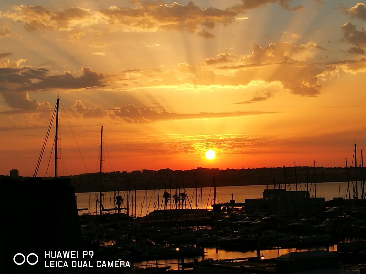 sunset, nautical vessel, transportation, mode of transport, boat, moored, water, sun, silhouette, orange color, sky, tranquil scene, scenics, tranquility, cloud, calm, sea, nature, beauty in nature, harbor, cloud - sky, outdoors, vibrant color, no people, outline, ocean, majestic, large group of objects, dramatic sky, romantic sky, cloudscape