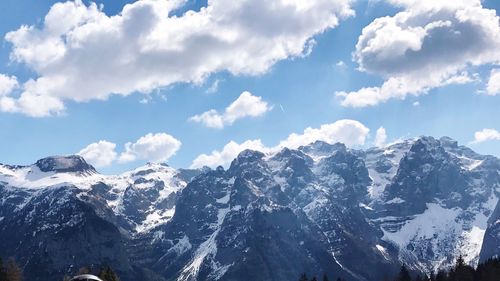 Low angle view of snow covered mountains against sky