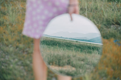 Low section of woman standing on field