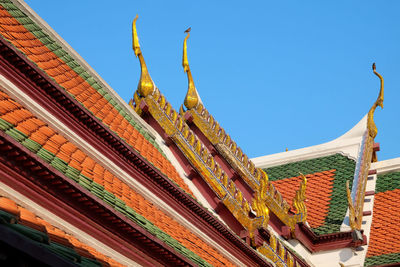 Low angle view of roof of building against blue sky