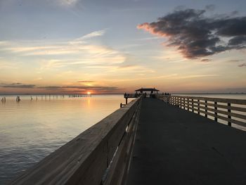 Pier over sea against sky during sunset