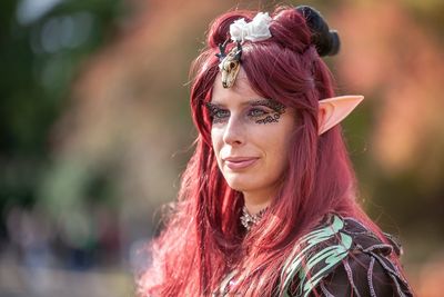 Mid adult woman wearing make-up while looking away outdoors