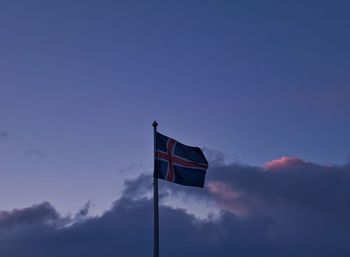 Low angle view of flag against blue sky