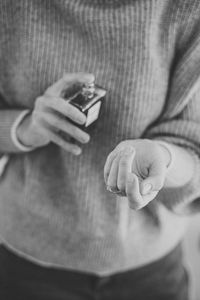 Hands of beautiful woman with bottle of floral perfume closeup. choosing a perfume, sexi aroma. 