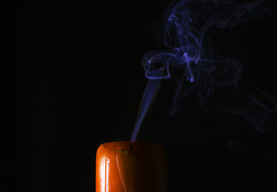 Close-up of tea light against black background