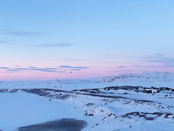 Scenic view of snow covered landscape against sky during sunset