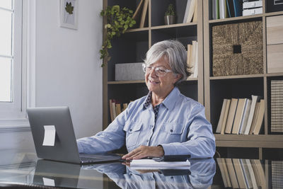 Portrait of young woman using digital tablet in library