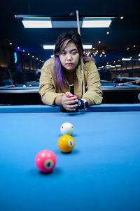 Portrait of woman playing pool