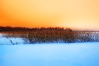 Scenic view of lake against clear sky during sunset