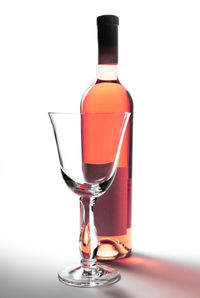 Close-up of wineglass on table against white background