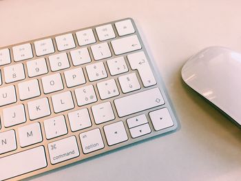 High angle view of computer keyboard and mouse on white table