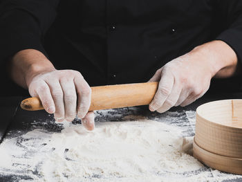 Midsection of man preparing food against black background