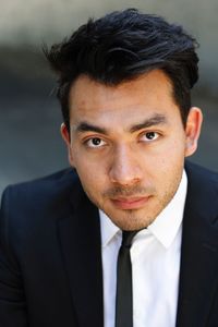 Portrait of young man wearing suit while standing outdoors