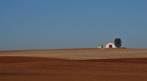 House on field against clear sky