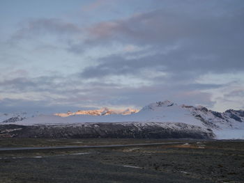 Idyllic shot of landscape and snowcapped mountains against sky