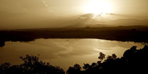 Scenic view of silhouette mountains against sky at sunset