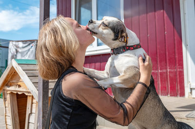 Rear view of woman with dog against sky