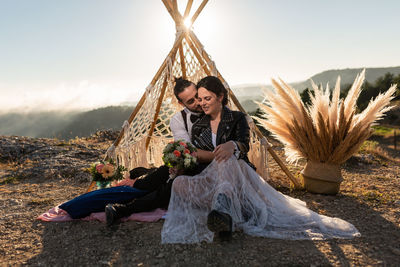 Couple embracing while sitting outdoors