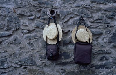 Low angle view of hats hanging on stone wall