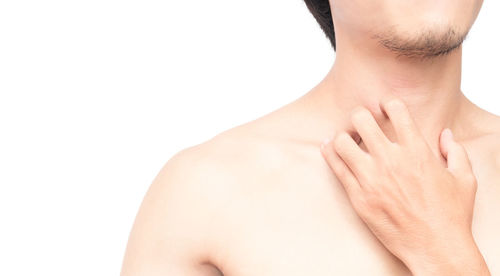 Close-up of shirtless man against white background