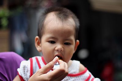 Close-up of mother feeding food to baby girl