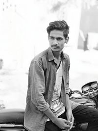 Young man sitting on motorcycle parked outdoors