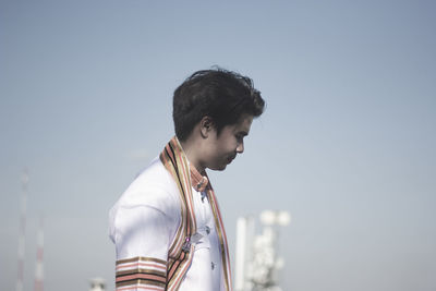 Man in traditional clothes standing against clear sky