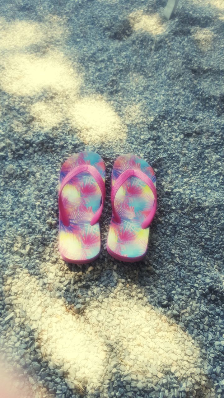 HIGH ANGLE VIEW OF PINK SHOES AT BEACH