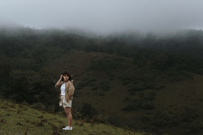 Full length of woman standing against foggy weather