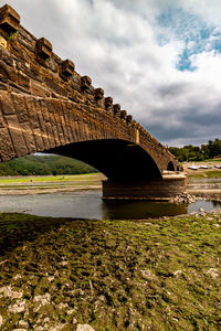 Arch bridge over river against sky