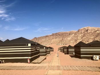 Houses by mountain against blue sky