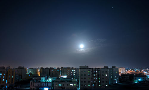 Illuminated buildings against sky at night