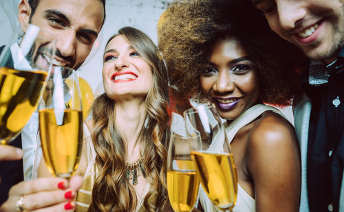 Smiling friends toasting champagne flutes