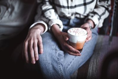 Midsection of couple sitting with coffee drink 