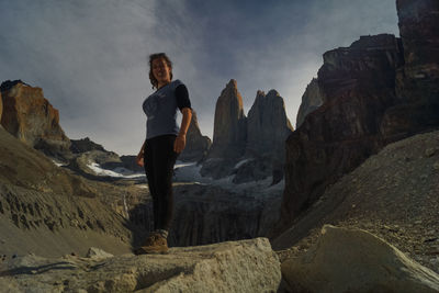 Low angle view of woman standing against mountain