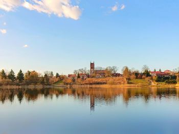 Scenic view of lake by building against sky