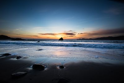 Scenic view of beach against sky during sunset