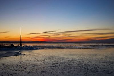 Scenic view of beach against sky during sunset