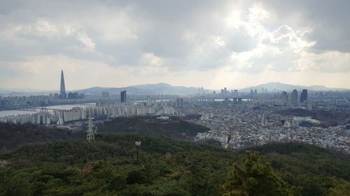 View of cityscape against cloudy sky