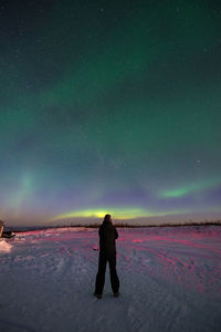 Full length of woman standing on field against sky at night