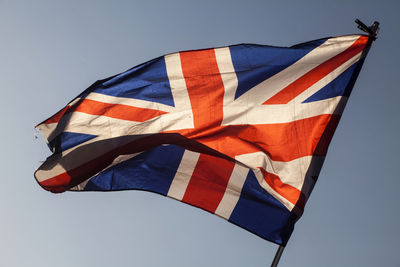 Low angle view of british flag waving against clear sky