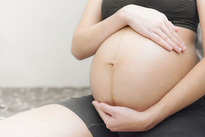 Midsection of woman touching finger